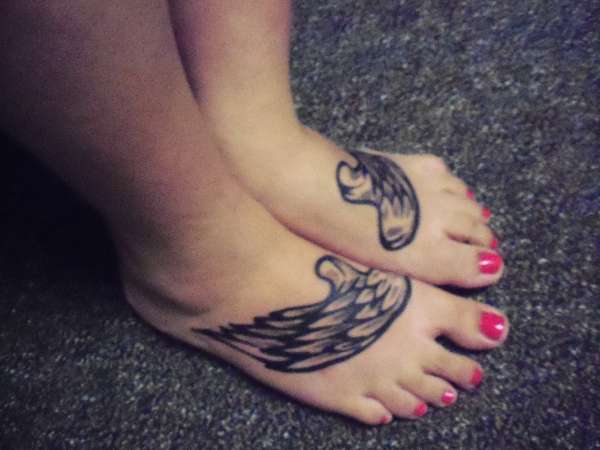 Angel wings on feet tattoo