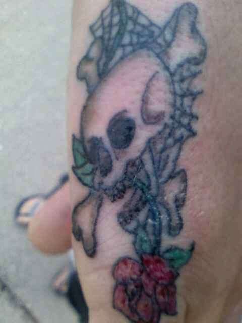 Skull and rose on my right pinky tattoo