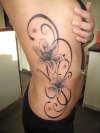 black and grey rib tattoo of tribal and  lilly tattoo