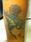 a gun wrapped by a rose tattoo