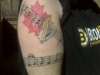 Maple leaf, Guinness Harp and notes tattoo