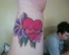 Wrist tattoo with heart and flowers