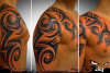 Tribal with shades on chest to arm tattoo