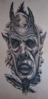 Demon ripping out of ribs tattoo
