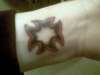 Iron cross on left wrist tattoo
