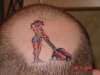 girl & lawnmower on head tattoo