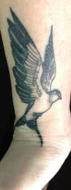 Side of wrist bird tattoo