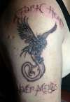 a Phoenix with lettering that says "a torn heart never minds" tattoo