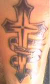 cross tat says "cuidame" meanin take care of me.. tattoo