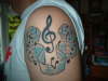 Treble clef with music notes tattoo