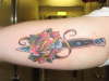 Switchblade through rose tattoo