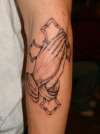 prayer hands and a cross tattoo
