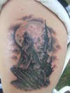 wolf howling off cliff tattoo