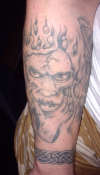 demon face thing with sewn up lips tattoo