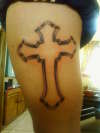 Cross upper leg tattoo