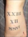 roman numerals on top of left foot tattoo