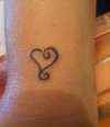"Love hurts" heart scroll on wrist tattoo